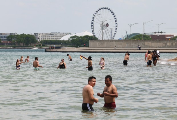 People play in the water at Oak Street Beach on May 21, 2024, in Chicago. (John J. Kim/Chicago Tribune)