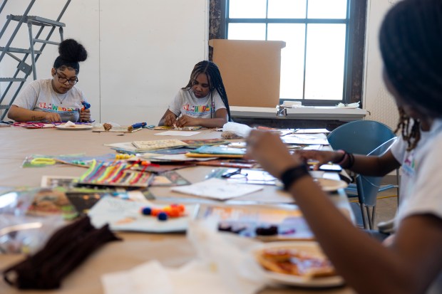 Jade Watkins, left, and Koby Byndon, both members of the One Lawndale Children's Discovery Center's Youth Advisory Council, work on an art project of children's book covers on May 1, 2024, at Nichols Tower in Chicago. The project will be exhibited at the Lawndale Pop-Up Spot. (Vincent Alban/Chicago Tribune)