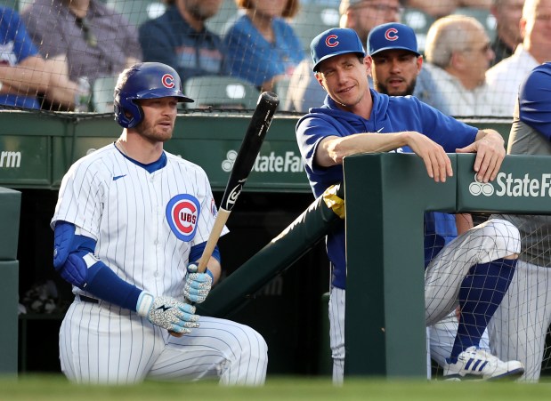 Chicago Cubs outfielder Ian Happ (left) and manager Craig Counsell (second from left) look on from the dugout in the first inning of a game against the Atlanta Braves at Wrigley Field in Chicago on May 21, 2024. (Chris Sweda/Chicago Tribune)