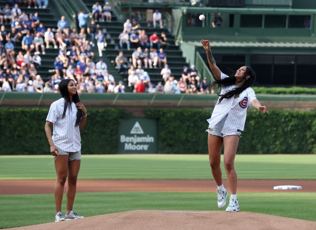 New Chicago Sky player Angel Reese (left) looks on as fellow Sky player Kamilla Cardoso throws out a ceremonial first pitch before a game between the Chicago Cubs and the Atlanta Braves at Wrigley Field in Chicago on May 21, 2024. (Chris Sweda/Chicago Tribune)