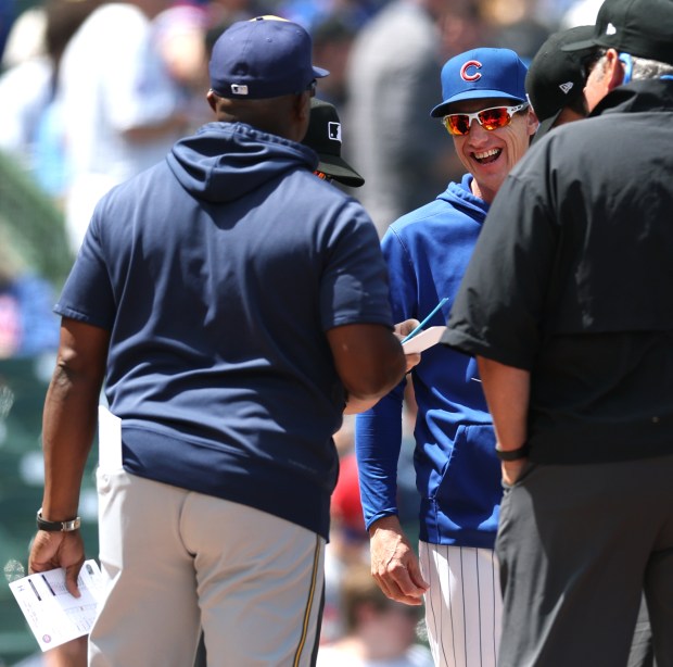 Cubs manager Craig Counsell has a laugh with a Brewers coach as the teams exchange lineups at home plate on Friday, May 3, 2024, at Wrigley Field. (Chris Sweda/Chicago Tribune)