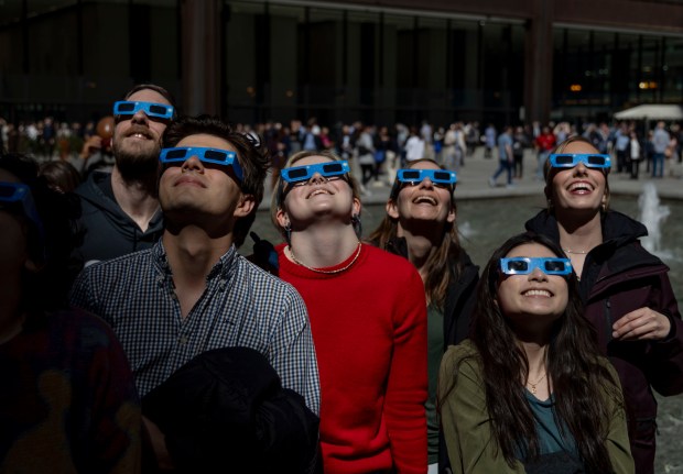 Chicagoans stand in Daley Plaza to watch the partial solar eclipse over the city, April 8, 2024. (Brian Cassella/Chicago Tribune)