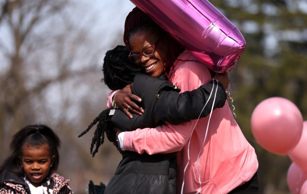 Misty Tiggs, right, receives a hug from Rose Lewis as Lewis and her daughter Zuri arrive to celebrate the birthday of Tigg's daughter, Rickisha King-Tiggs, at her gravesite on March 29, 2024. Rose and Rickisha were close friends and attended high school together. (Chris Sweda/Chicago Tribune)