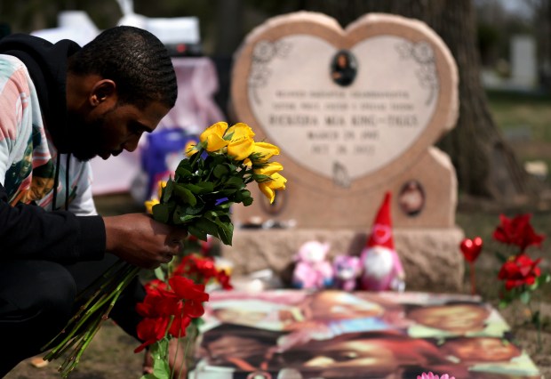 Adoness Baucom places flowers at the gravesite of his girlfriend, Rickisha King-Tiggs at Forest Home Cemetery on March 29, 2024. (Chris Sweda/Chicago Tribune)