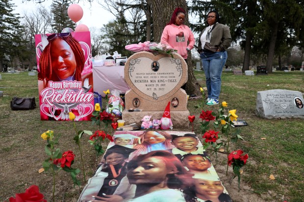 Misty Tiggs chats with Juatise Gathings, right, at the gravesite of Tiggs' daughter Rickisha as friends and family celebrate her birthday at Forest Home Cemetery on March 29, 2024. Gathings was Rickisha's former boss. (Chris Sweda/Chicago Tribune)