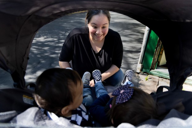 Christina Gonzalez buckles her infant twins into a stroller as they prepare for a walk to a nearby park on April 30, 2024, in Des Plaines. (Stacey Wescott/Chicago Tribune)