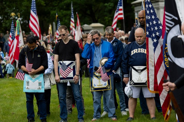 People bow their heads during the annual Rosehill Memorial Day cemetery ceremony on May 27, 2024, at Rosehill Cemetery in Chicago. (Vincent Alban/Chicago Tribune)