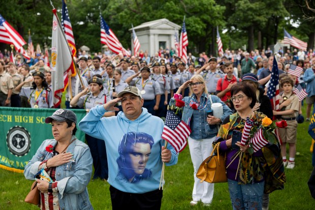 U.S. Army veteran Olga Lopez, second from left, salutes the flag during the annual Memorial Day ceremony at Rosehill Cemetery on Chicago's North Side on May 27, 2024. (Vincent Alban/Chicago Tribune)