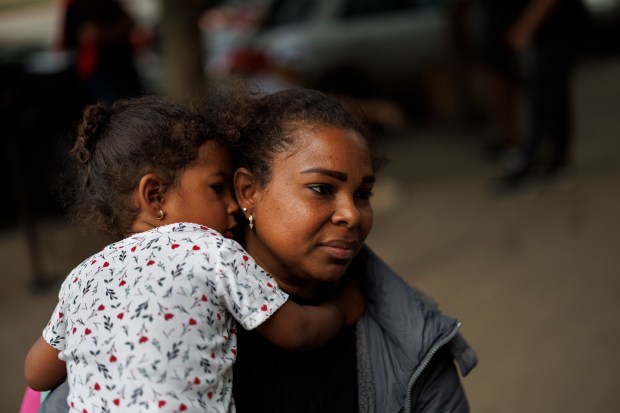 Bleidys Bonolli, 40, from Columbia, holds her daughter Angely Acosta, 2, while standing outside a migrant shelter on North Ogden Avenue on May 16, 2024. (Armando L. Sanchez/Chicago Tribune)