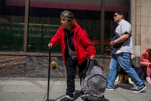 Gladys Heredia, 58, from Peru, walks near a migrant shelter at the Inn of Chicago on May 17, 2024. Heredia says she lost her toe while on the journey from Peru to the U.S. (Armando L. Sanchez/Chicago Tribune)