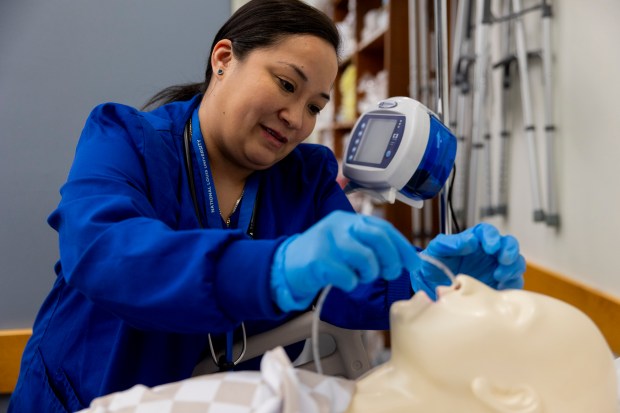 Lara Romero performs a nasal gastric tube insertion exercise during a lab class on May 10, 2024, at National Louis University in Chicago. (Vincent Alban/Chicago Tribune)