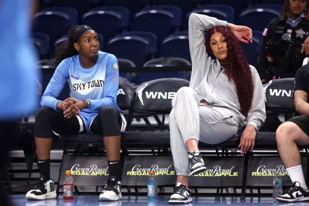 Chicago Sky center Elizabeth Williams, left, and injured center Kamilla Cardoso relax on the bench as players warm up for the home opener against the Connecticut Sun on May 25, 2024, at Wintrust Arena. (Chris Sweda/Chicago Tribune)
