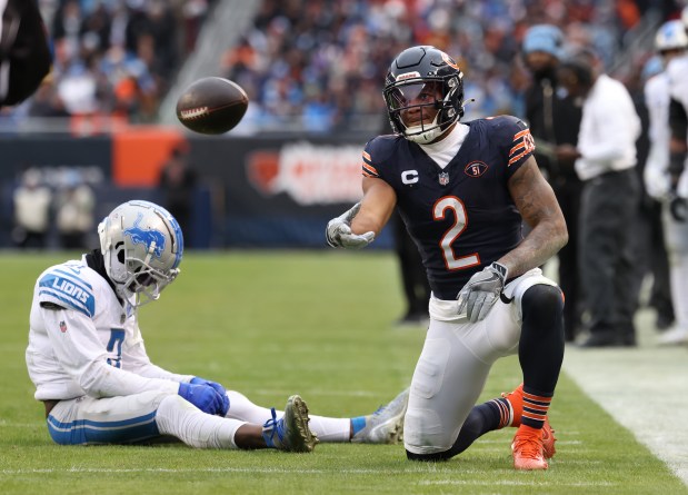 Bears wide receiver DJ Moore tosses the ball after a reception as Lions safety Kerby Joseph sits on the turf in the fourth quarter at Soldier Field on Dec. 10, 2023. (John J. Kim/Chicago Tribune)