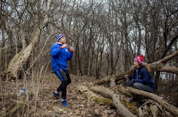 Olympic hopeful Joe Rau practices wrestling moves as his then-girlfriend, wife Astrid De Leeuw, times his increments while working out on March 22, 2020 near his home in Des Plaines. (Brian Cassella/Chicago Tribune)