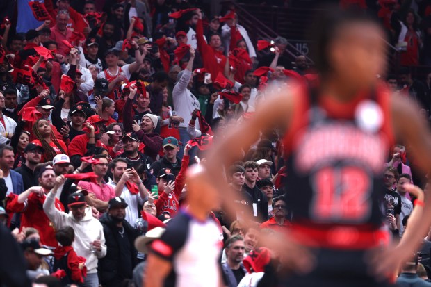 Bulls fans wave red towels while cheering at the beginning of a play-in game against the Hawks at the United Center on April 17, 2024. (Chris Sweda/Chicago Tribune)