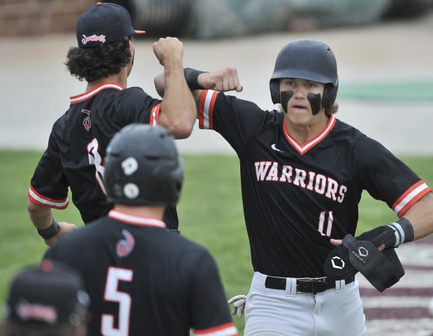 Lincoln-Way West's Cole Crafton (11) gets greeted by his teammates after scoring a run against the host Porters during the Class 4A Lockport Sectional championship game on Saturday, June 4, 2022.