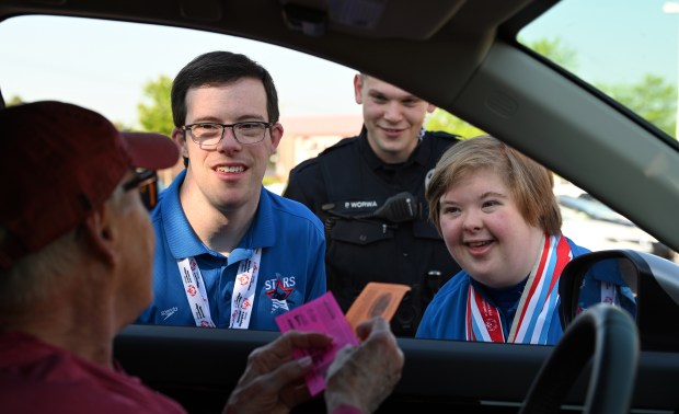 From left to right, wearing blue, are Special Olympics athletes Blake Peacock of Libertyville and Tempest McKenzie of Lindenhurst at Cop on a Rooftop on May 17, 2024 at Dunkin' in Libertyville at 210 Peterson Road. (Karie Angell Luc/Lake County News-Sun)