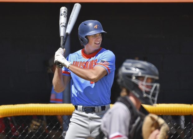 Naperville North's Jackson Prentice swings two bats as he times the Glenbard East relief pitcher that he will face warm up during a game on Saturday, May 11, 2024, in Naperville.(Jon Cunningham/for The Naperville Sun)