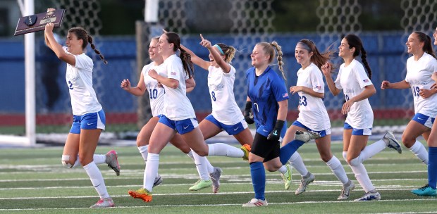 St. Charles North's Kayla Floyd (2) leads her teammates as she carries the first place plaque after their 2-1 win over Naperville Central in the Class 3A St. Charles North Supersectional on Tuesday, May 28, 2024 in St. Charles. St. H. Rick Bamman / For the Beacon-News