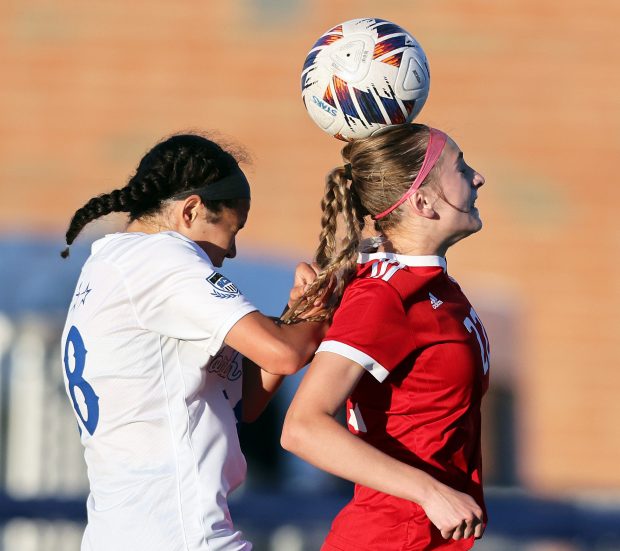 Naperville Central's Nicole Sacek (22) heads the ball in front of St. Charles North's Juliana Park (18) in the second half during the Class 3A St. Charles North Supersectional on Tuesday, May 28, 2024 in St. Charles. St. Charles North won, 2-1.H. Rick Bamman / For the Naperville Sun