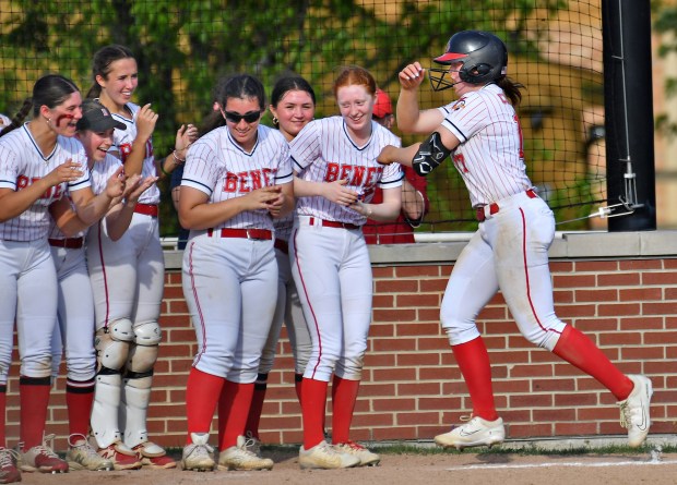 Bridget Chapman (right) is greeted by Benet teammates as she arrives to score after hitting a home run during a Class 4A Hinsdale Central Regional semifinal game against Hinsdale Central on Tuesday, May 21, 2024, in Hinsdale.(Jon Cunningham/for The Naperville Sun)