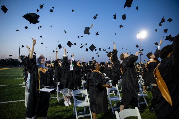 Graduates toss their caps in the air at the conclusion of the Hinsdale South High School commencement ceremony on the football field Thursday, May 23, 2024 in Darien, Illinois. ( John Konstantaras-Pioneer-Press ) - PPN-L-Hinsdale-South-Grad-0530 00077849A