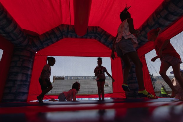 Area children play in a bounce house during a community block party at Oak Park-River Forest high school to celebrate the school's 150th anniversary on Sunday May 20, 2024. (Troy Stolt/for the Pioneer Press)