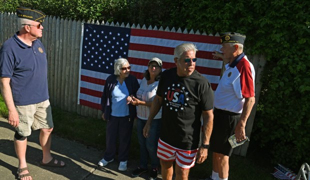 From left to right, all of Northbrook, Tom Kittler, Eleanor Nalven, Beth Koeppen, Larry Rosenthal and Rob Holt after the installation of the American flag on a residential fence at Dundee Road and Bach Street on May 25, 2024 in Northbrook. (Karie Angell Luc/Pioneer Press)