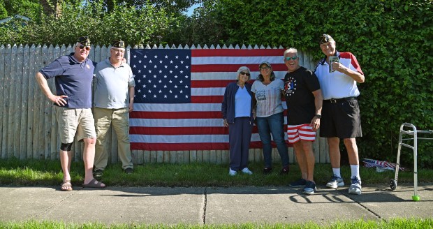 From left to right, Tom Kittler of Northbrook, Richard J. Kennedy of Wheeling, Eleanor Nalven of Northbrook, Beth Koeppen of Northbrook, Larry Rosenthal of Northbrook and Rob Holt of Northbrook after the installation of the American flag on a residential fence at Dundee Road and Bach Street on May 25, 2024 in Northbrook. (Karie Angell Luc/Pioneer Press)