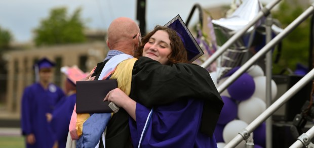 From left, Niles North Principal James B. Edwards gives an embrace to graduate Jamie Kimmel-Choldin of Morton Grove at graduation at Niles North High School on May 27, 2024 in Skokie. (Karie Angell Luc/Pioneer Press)