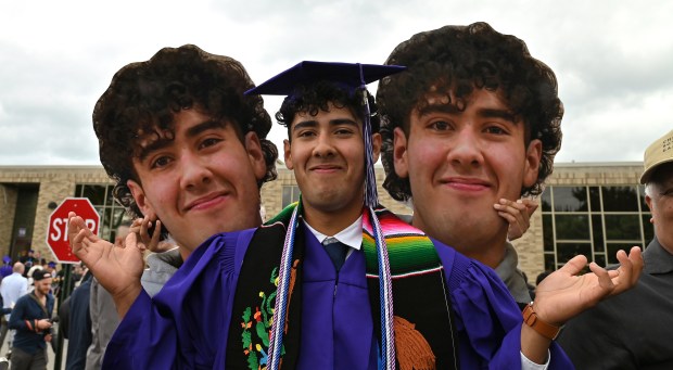 The photograph cutouts were a surprise by the family. Graduate Alejandro Campos, 18, of Skokie, is a good sport among family, fans and friends after graduation at Niles North High School on May 27, 2024 at Chuck Pos Stadium (9800 Lawler Ave.) in Niles. (Karie Angell Luc/Pioneer Press)