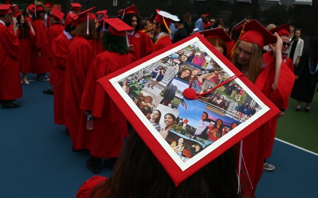 Verina Stasinopoulos, 18, of Skokie has photos of friends from middle school on the top of the mortarboard at graduation at Niles West High School in Skokie on May 27, 2024. (Karie Angell Luc/Pioneer Press)