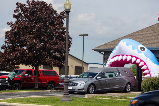 The hearse carrying the coffin of 10-year old Dakota Levi Stevens, leaves the funeral home under a giant-inflatable shark, his favorite animal, Monday, May 6, 2024, in Crown Point. (Vincent D. Johnson/for the Post-Tribune)