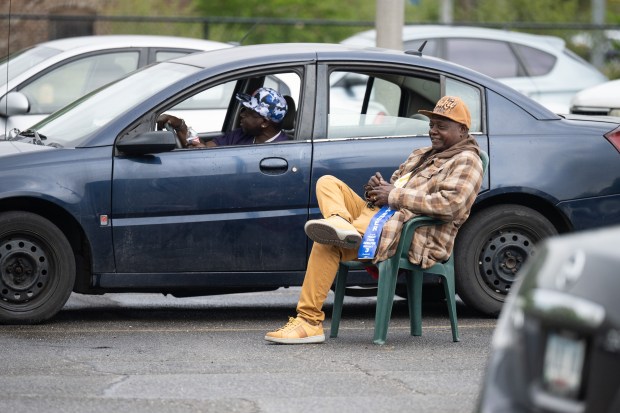 Gary residents Edward Mathews, on right, and Wendell Brown promote candidates in the parking lot outside of the polling location at the Gary Public Library on election day, Tuesday, May 7, 2024. (Kyle Telechan/for the Post-Tribune)