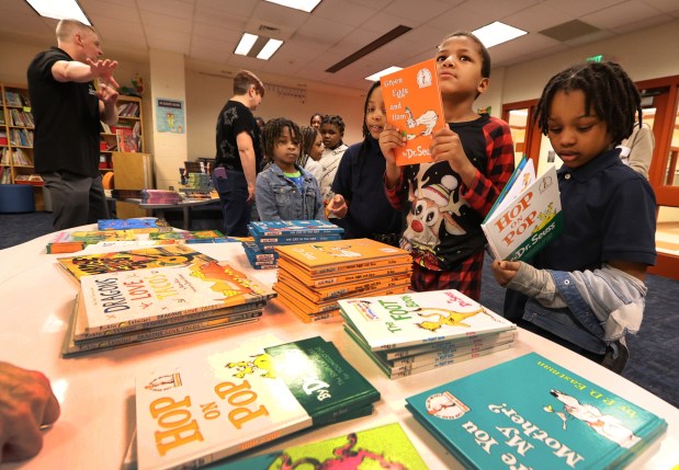 Second grader Darrell Cross 8, (center right) holds up a book he picked for his mom during the 2nd Annual Mother's Day Book Give Away hosted by the School House Children Charity at Glen Park Academy in Gary on Friday, May 10, 2024. (John Smierciak/for the Post Tribune)