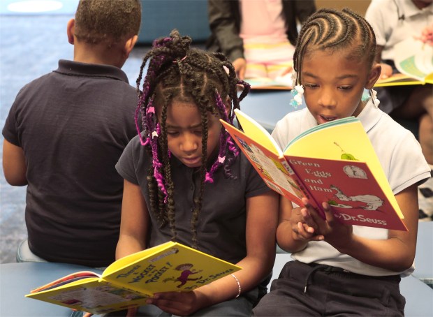 Second graders Kaylani Sanders 8, and Aujuniquen Rice 8, ( l to r) read the books that they picked out for their moms during the 2nd Annual Mother's Day Book Give Away hosted by the School House Children Charity at Glen Park Academy in Gary on Friday, May 10, 2024. (John Smierciak/for the Post Tribune)