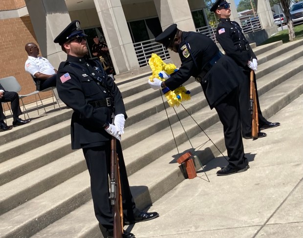 Members of the Hammond Police Department add carnations to a memorial star Wednesday to honor the department's fallen. (Carrie Napoleon/Post-Tribune)