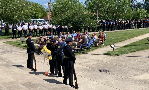 Officers place one red carnation on a memorial star Wednesday for each of eight Hammond Police officers who lost their lives in the line of duty during the annual FOP memorial. (Carrie Napoleon/Post-Tribune)