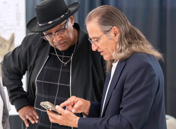 Peter Coulopoulos, owner of Summit scrapyard in Gary, shows State Sen. Lonnie Randolph, D-East Chicago, information on his phone after an Indiana Department of Environmental Management hearing on Wednesday, May 15, 2024. (Michael Gard/for the Post-Tribune)