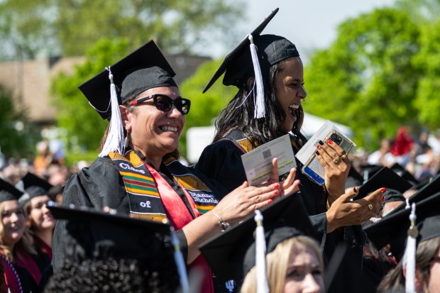 Indiana University Northwest graduates Kaitlin Nichols, on right, and her mother Dianne Nichols stand to be recognized during the Indiana University Northwest commencement ceremonies on Wednesday, May 8, 2024. (Kyle Telechan/for the Post-Tribune)