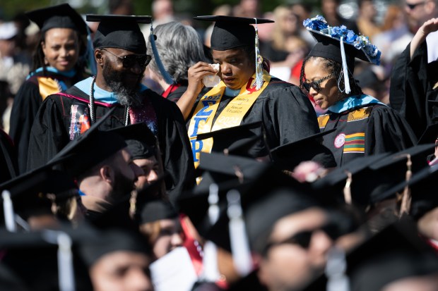 A soon-to-be graduate dabs her eye with a tissue as she and her classmates make their way to their seats at the Indiana University Northwest commencement ceremonies on Wednesday, May 8, 2024. (Kyle Telechan/for the Post-Tribune)