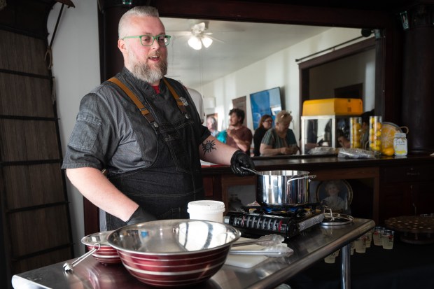 Museum at Lassen's Resort chef Erik A. Hinds cooks "Flapper Popcorn", duck fat popcorn infused with white chocolate and lavender, for guests during a celebration of the opening of the 2024 season at the museum in Cedar Lake on Friday, May 3, 2024. (Kyle Telechan/for the Post-Tribune)