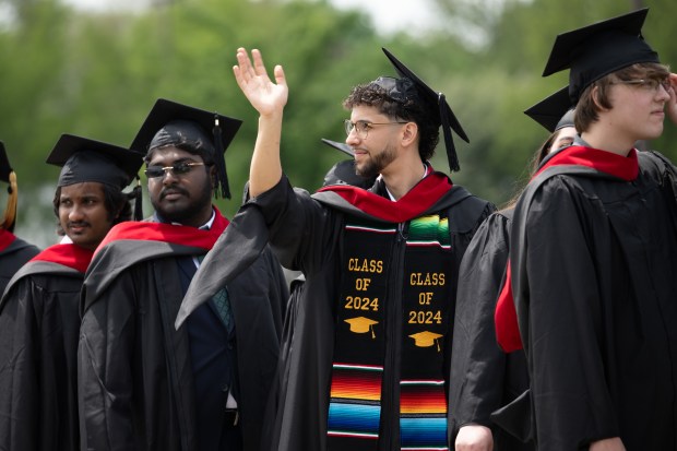 Soon-to-be-graduates wave to family and friends from the procession line during Purdue University Northwest's spring commencement ceremony on Saturday, May 4, 2024, in Hammond. (Kyle Telechan/for the Post-Tribune)