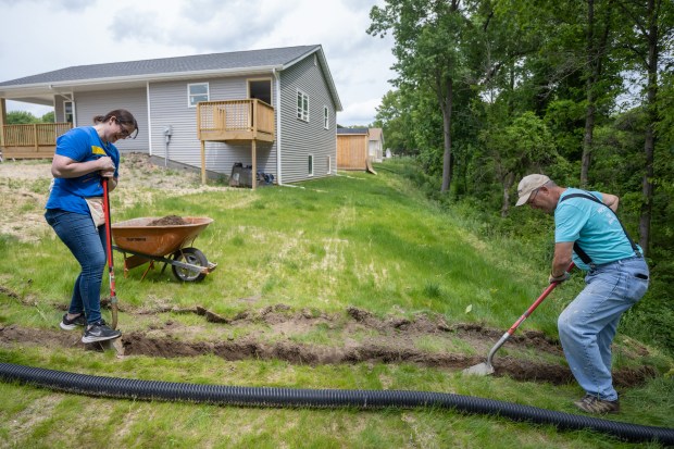 Volunteers Gerica Vega, on left, and Mike Furlan dig a trench for a drainage pipe as workers gather to participate in Habitat For Humanity Northwest Indiana's Honor Build event on Friday, May 24, 2024. (Kyle Telechan/for the Post-Tribune)