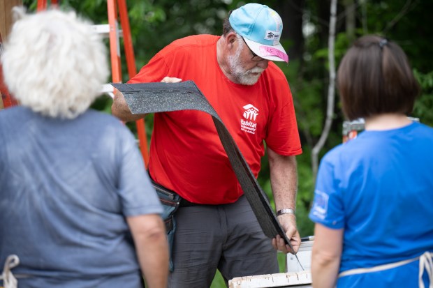 Habitat for Humanity core volunteer Keith Bruxvoort cuts shingles to size as he and other volunteers work on a shed as part of the program's Honor Build event on Friday, May 24, 2024. (Kyle Telechan/for the Post-Tribune)