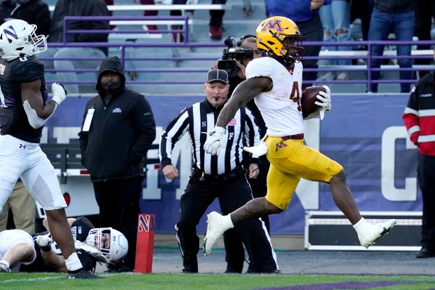 Minnesota running back Mar'Keise Irving, right, scores a touchdown past Northwestern linebacker Chris Bergin and defensive back Coco Azema during the second half Saturday in Evanston. The Gophers won 41-14.