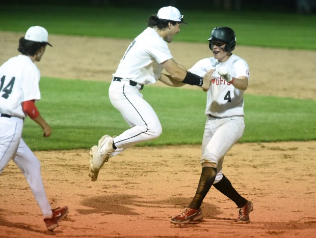 Lincoln-Way Central's Braden Meyer (4) is met by Collin Mowry (17) and his teammates after a walk off winner against Lincoln-Way East during a Southwest Suburban Conference game Friday, May 17, 2024 in New Lenox, IL. (Steve Johnston/Daily Southtown)