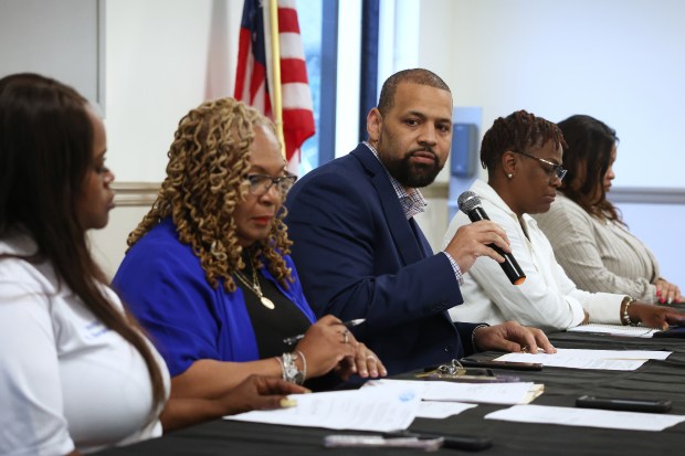 Dolton Village Trustee Jason House, with microphone, leads a special meeting of the Dolton Village Board May 13, 2024. At the dias, from left, are Trustee Brittney Norwood, Village Clerk Alison Key, House, Trustee Tammy Brown and Trustee Kiana Belcher. (Terrence Antonio James/Chicago Tribune)