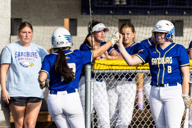 Sandburg's Paige Zikmund (13) gets a high-five from Zoe Jeanes (8) on her way into the dugout after scoring against Lemont during a nonconfernece game in Orland Park on Wednesday, May 1, 2024. (Vincent D. Johnson/for the Daily Southtown)