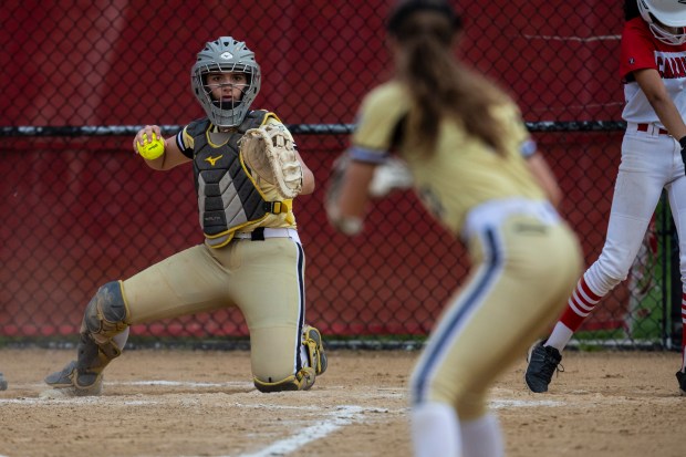 Oak Forest's catcher Morgan Reczkiewicz, gets ready to fire the ball to Jenna Hughes at first base as an Eisenhower runner takes a lead off during a South Suburban crossover game in Blue Island on Monday, May 20, 2024. (Vincent D. Johnson/for the Daily Southtown)